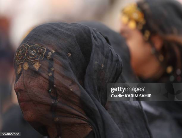 Moroccan girl from the southern desert performs during a fantasia as part of the 14th Tan-Tan Moussem Berber festival on July 08, 2018 in the western...