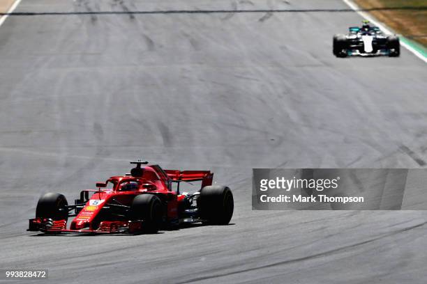 Sebastian Vettel of Germany driving the Scuderia Ferrari SF71H leads Valtteri Bottas driving the Mercedes AMG Petronas F1 Team Mercedes WO9 on track...