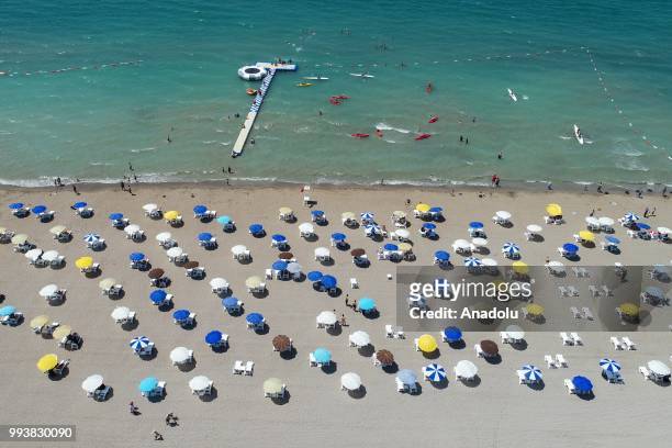 Drone photo shows that people swim and sunbathe during a hot summer day at newly opened public beach on the shore of Van Lake on July 8, 2018 in Van,...