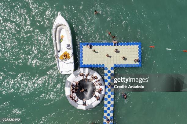 Drone photo shows that people swim and sunbathe during a hot summer day at newly opened public beach on the shore of Van Lake on July 8, 2018 in Van,...