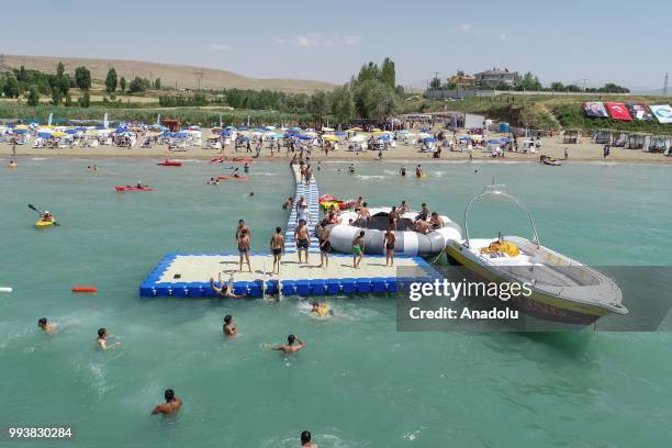 Photo shows that people swim and sunbathe during a hot summer day at newly opened public beach on the shore of Van Lake on July 8, 2018 in Van,...