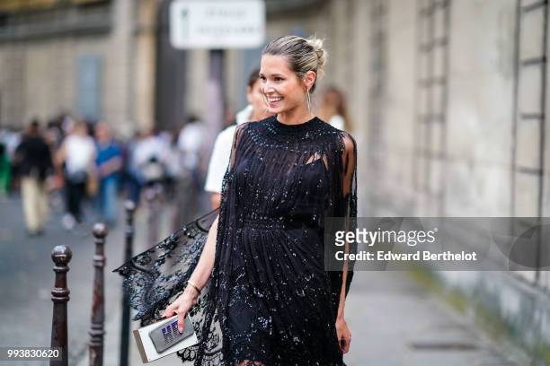 Helena Bordon wears a black lace mesh dress, black heels shoes, outside Valentino, during Paris Fashion Week Haute Couture Fall Winter 2018/2019, on...