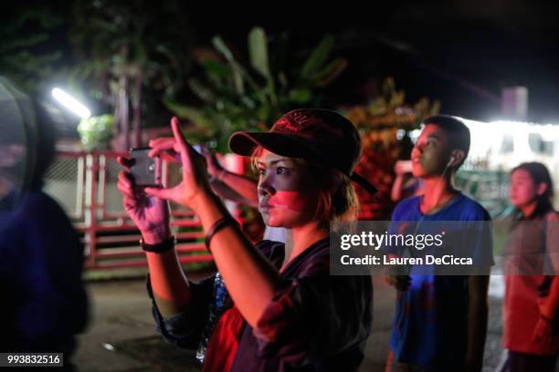 Onlookers watch and cheer as ambulances deliver boys rescued from a cave in northern Thailand to hospital in Chiang Rai after they were transported...