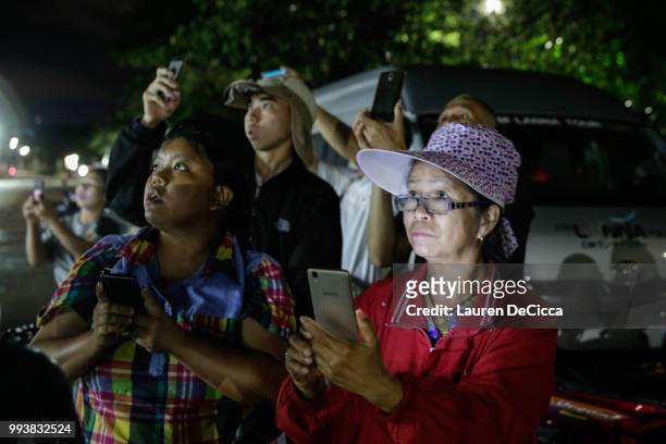 Onlookers watch and cheer as ambulances deliver boys rescued from a cave in northern Thailand to hospital in Chiang Rai after they were transported...