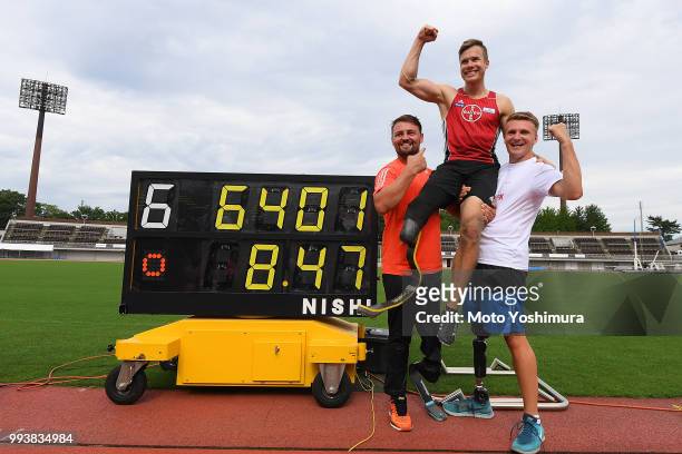 Markus Rehm of Germany is congratulated by Heinrich Popow of Germany and Daniel Jorgensen of Denmark after achieving the new world record of 8m47 in...
