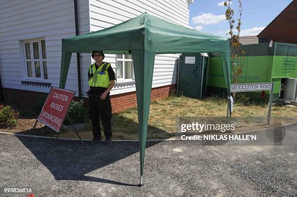 Police officers stand guard at a residential house in Amesbury, southern England, on July 8, 2018. - The exposure of an apparently random British...