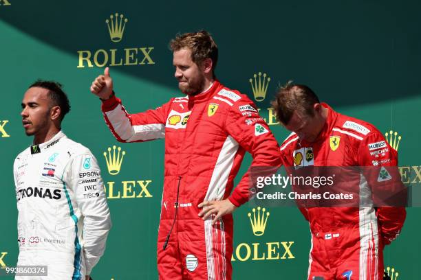 Top three finishers Sebastian Vettel of Germany and Ferrari, Lewis Hamilton of Great Britain and Mercedes GP and Kimi Raikkonen of Finland and...