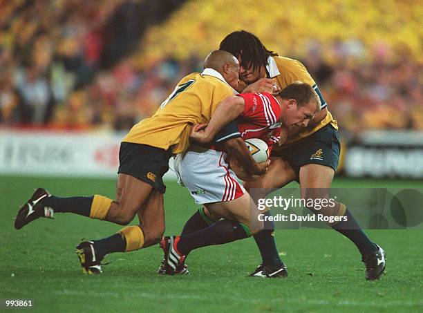 Matt Dawson of the British and Irish Lions is tackled by George Gregan and George Smith of Australia during the third Test Match between the British...