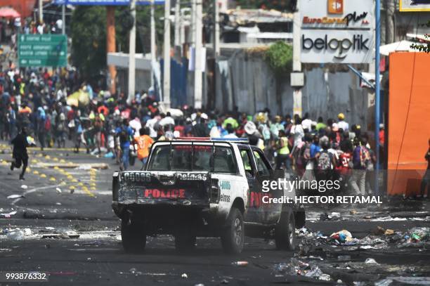 People flee from the Haitian police after looting in shops in Delmas a commune near Port au Prince during protests against the rising price of fuel,...