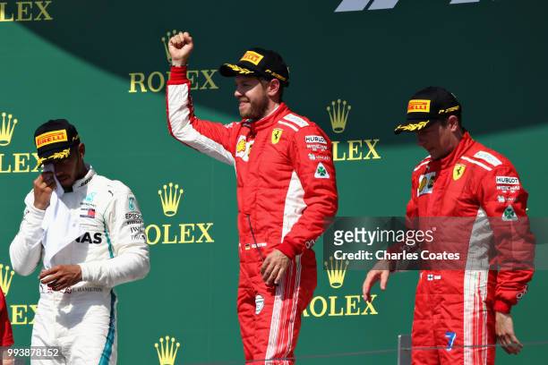 Top three finishers Sebastian Vettel of Germany and Ferrari, Lewis Hamilton of Great Britain and Mercedes GP and Kimi Raikkonen of Finland and...