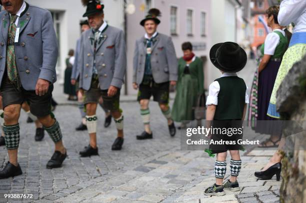 Young boy attends people in traditional Bavarian costums attend a parade celebrating the 125th anniversary of the local...