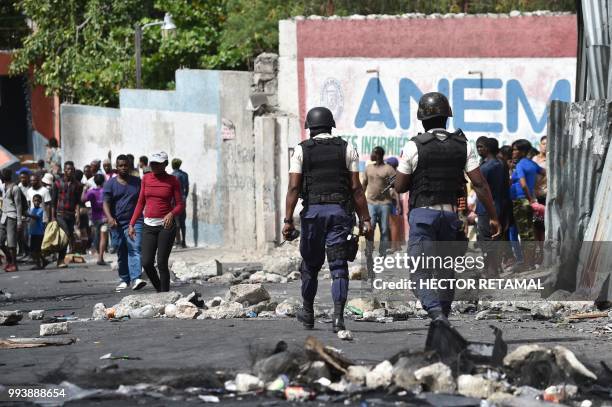 Haitian police arrive to control the situation after looting at a store in Delmas, a commune near Port-au-Prince, during protests against the rising...