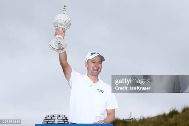 Russell Knox of Scotland celebrates with the trophy following his victory on the 18th green during a playoff at the end of the final round of the...