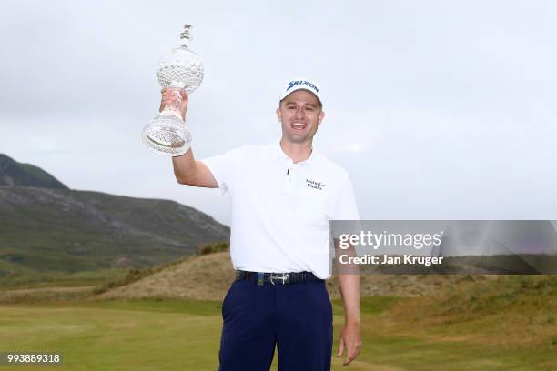 Russell Knox of Scotland celebrates with the trophy following his victory on the 18th green during a playoff at the end of the final round of the...