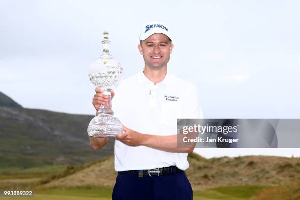 Russell Knox of Scotland celebrates with the trophy following his victory on the 18th green during a playoff at the end of the final round of the...