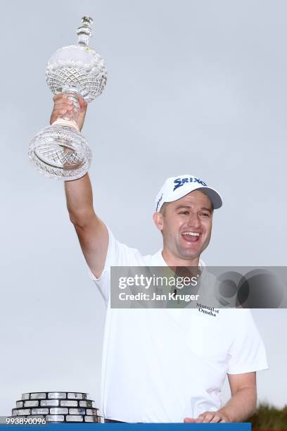 Russell Knox of Scotland celebrates with the trophy following his victory on the 18th green during a playoff at the end of the final round of the...
