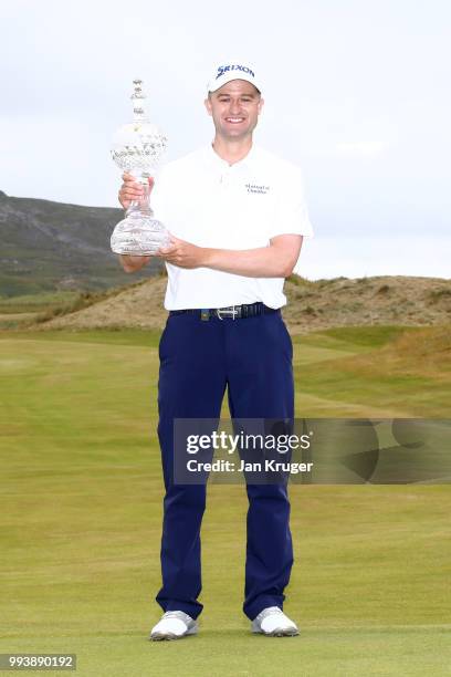 Russell Knox of Scotland poses with the trophy following his victory on the 18th green during a playoff at the end of the final round of the Dubai...