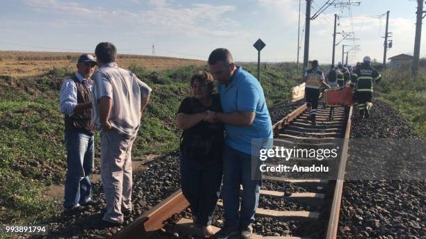 Passengers are seen as health team workers are dispatched to the scene after several bogies of a passenger train derailed at the Sarilar village of...