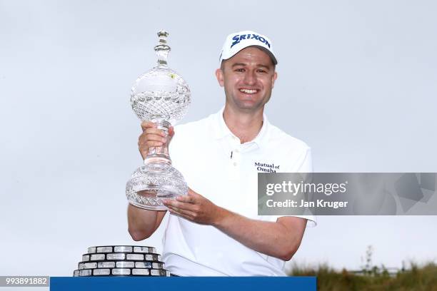 Russell Knox of Scotland poses with the trophy following his victory on the 18th green during a playoff at the end of the final round of the Dubai...