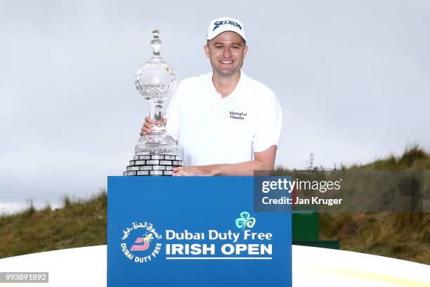 Russell Knox of Scotland poses with the trophy following his victory on the 18th green during a playoff at the end of the final round of the Dubai...