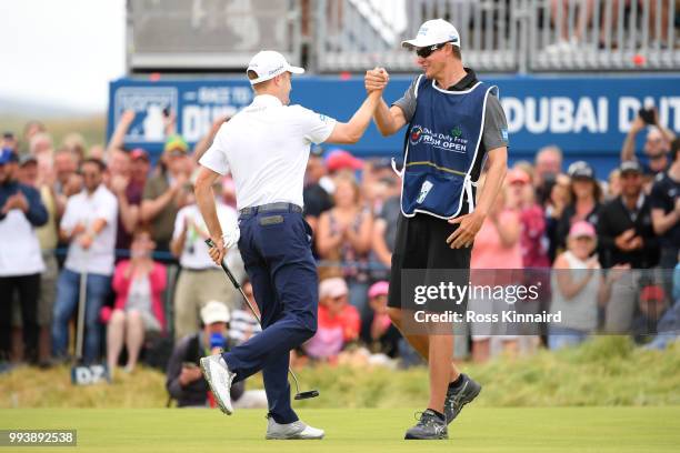 Russell Knox of Scotland celebrates holing a putt for victory on the 18th green with his caddie James Williams during a playoff at the end of the...