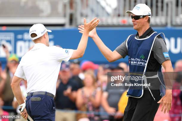 Russell Knox of Scotland celebrates holing a putt for victory on the 18th green with his caddie James Williams during a playoff at the end of the...