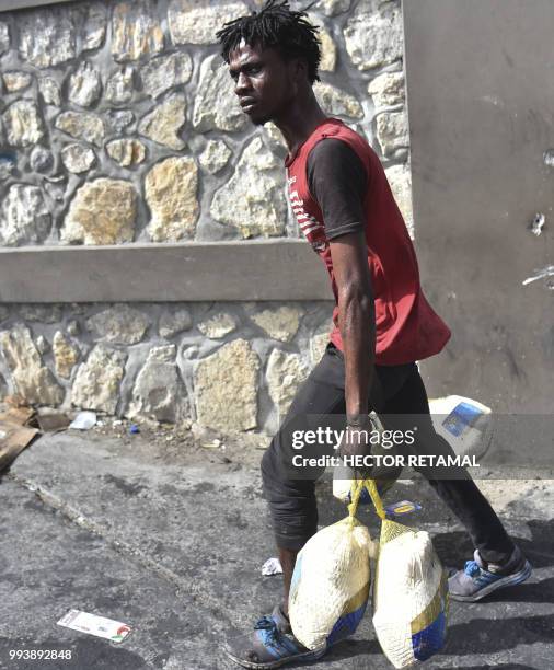 Looter flees with food, as Haitian police arrive to control the situation in Delmas, a commune near Port-au-Prince, during protests against the...