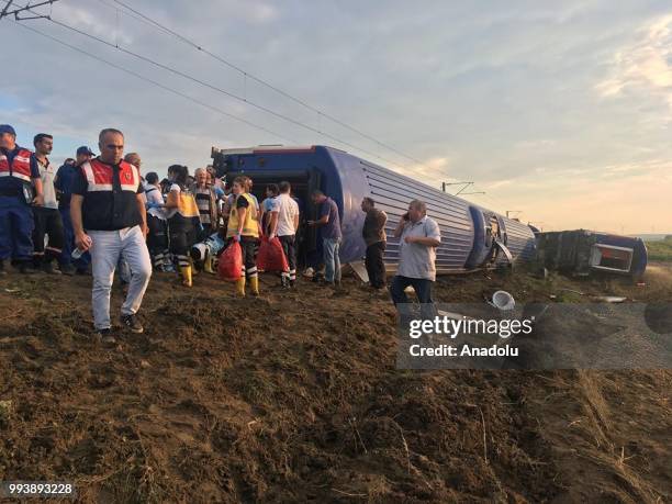 People inspect the scene after several bogies of a passenger train derailed at the Sarilar village of Tekirdags Corlu district on July 8, 2018. The...