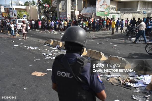 Haitian police arrive to control the looters at a market in Delmas, a commune near Port-au-Prince, during protests against the rising price of fuel,...
