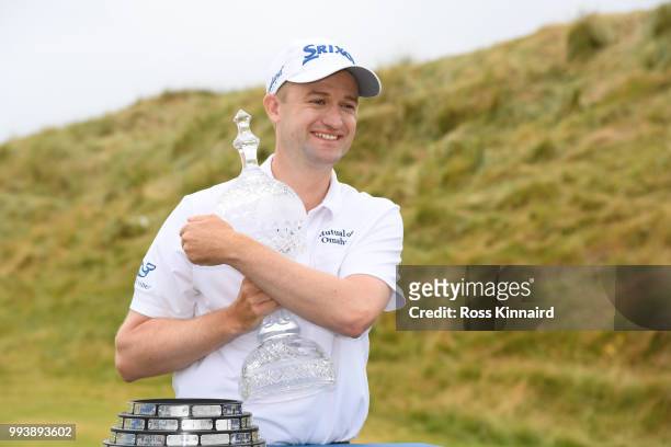 Russell Knox of Scotland poses with the trophy following his victory on the 18th green during a playoff at the end of the final round of the Dubai...