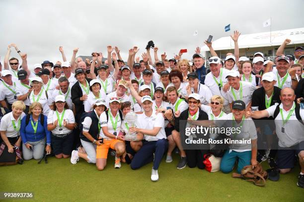 Russell Knox of Scotland poses with marshalls and volunteers following his victory on the 18th green during a playoff at the end of the final round...