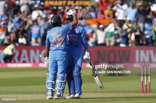 India's Rohit Sharma and India's Hardik Pandya celebrate after hitting the winning runs during the third international Twenty20 cricket match between...