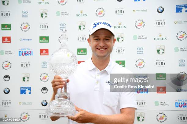Russell Knox of Scotland poses with the trophy following his victory on the 18th green during a playoff at the end of the final round of the Dubai...