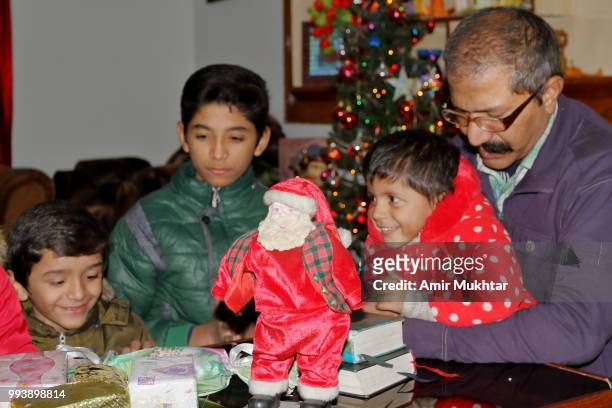 a pakistani christian children praying and worshiping with their father on the eve of christmas 2017 - amir mukhtar stock pictures, royalty-free photos & images