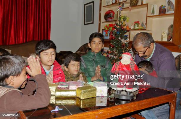 a pakistani christian children praying and worshiping with their father on the eve of christmas 2017 - amir mukhtar stock pictures, royalty-free photos & images