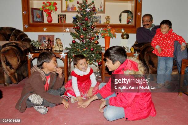 pakistani christian children playing and enjoying in the presence of their father on the eve of christmas 2017 - amir mukhtar stock pictures, royalty-free photos & images