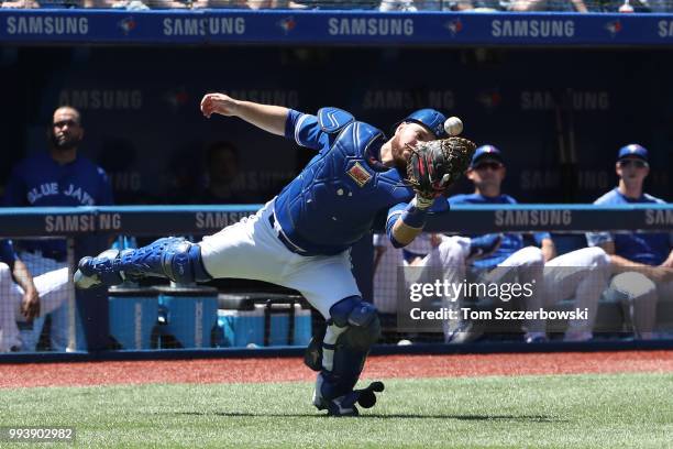 Russell Martin of the Toronto Blue Jays bobbles a foul pop up but holds on for the catch in the first inning during MLB game action against the New...