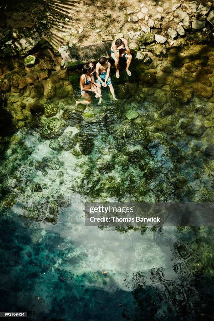 Overhead view of family sitting on edge of cenote after swim