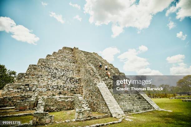 family climbing pyramid while exploring mayapan ruins during vacation - off the beaten path foto e immagini stock