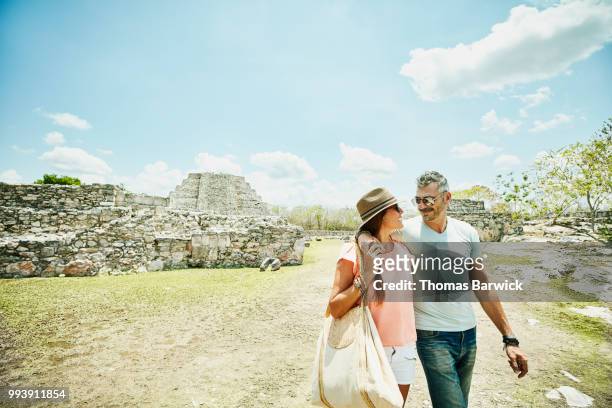 smiling wife and husband with arms around each other exploring mayapan ruins during vacation - spanish royals host a lunch for president of mexico and his wife stockfoto's en -beelden