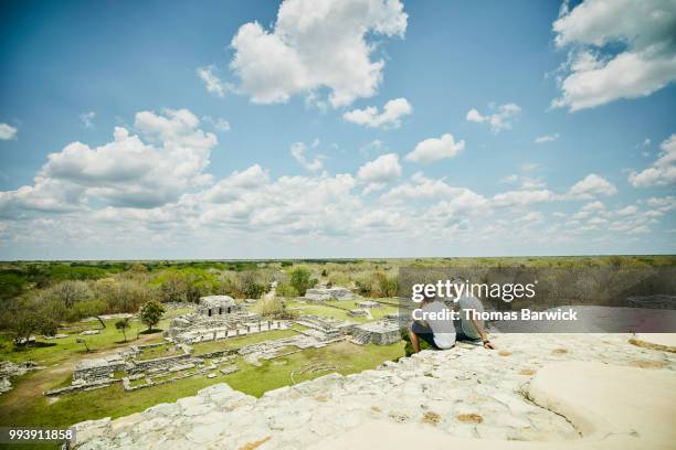 father and son sitting together at top of pyramid while exploring mayapan ruins - latin american civilizations - fotografias e filmes do acervo