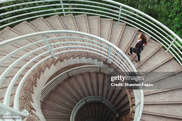 business woman walking on spiral staircase in hong kong - wendeltreppe stock-fotos und bilder