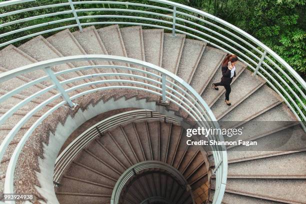 business woman walking on spiral staircase in hong kong - spiral staircase stock pictures, royalty-free photos & images