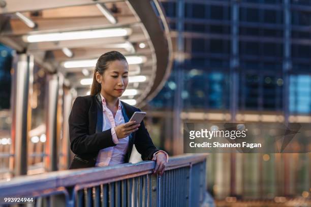 business woman standing on pedestrian bridge at night - pedestrian overpass stock pictures, royalty-free photos & images