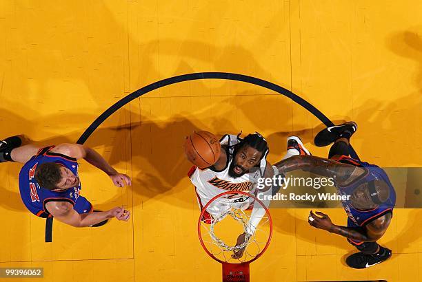 Ronny Turiaf of the Golden State Warriors rebounds against David Lee and Al Harrington of the New York Knicks during the game at Oracle Arena on...