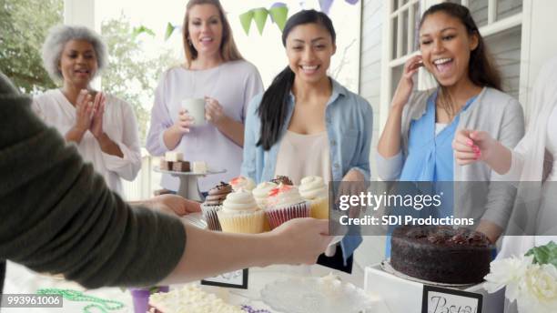 charitable group receiving cupcakes at a party - bake sale stock pictures, royalty-free photos & images