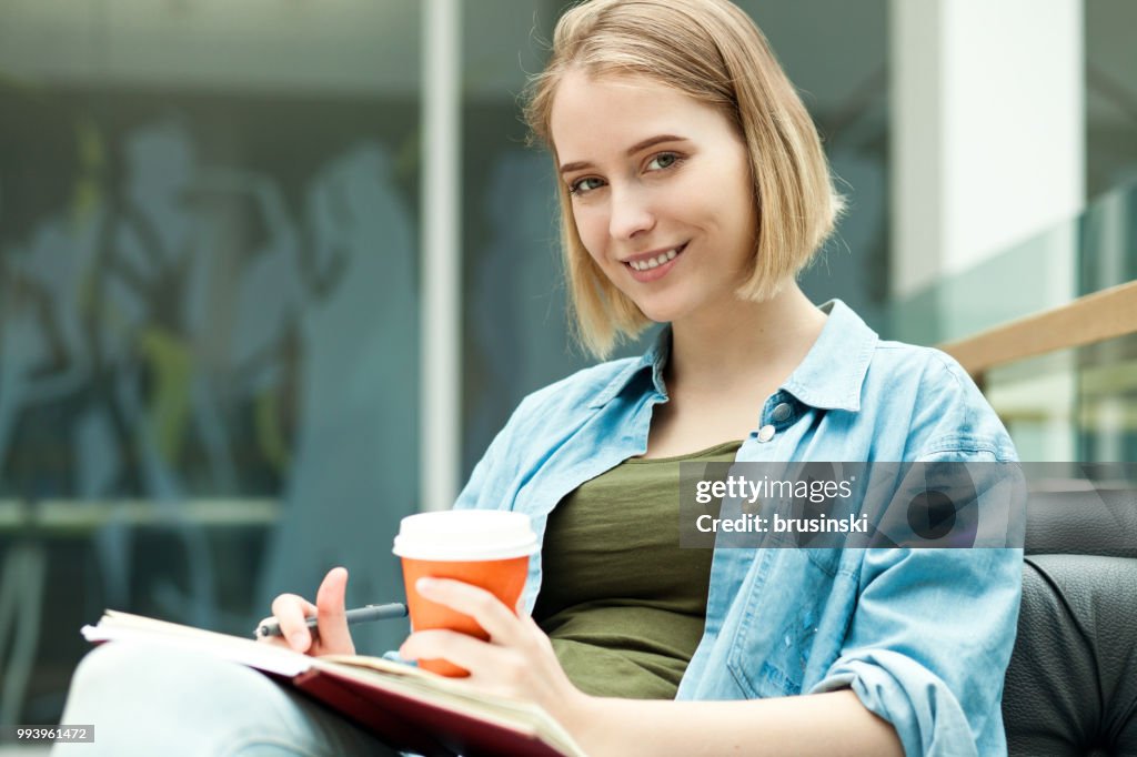 A young attractive woman of 20 years draws in a sketchbook