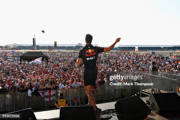 Daniel Ricciardo of Australia and Red Bull Racing entertains the crowd on the fan stage after the Formula One Grand Prix of Great Britain at...