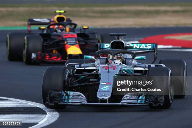 Lewis Hamilton of Great Britain driving the Mercedes AMG Petronas F1 Team Mercedes WO9 leads Max Verstappen of the Netherlands driving the Aston...