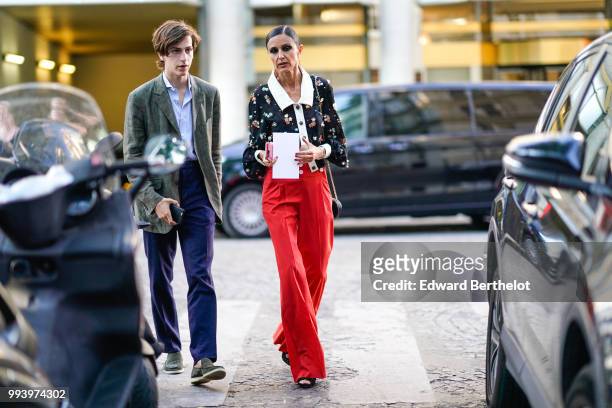 Guest wears a floral print black lace mesh shirt with a white collar, red flared pants, outside Valentino, during Paris Fashion Week Haute Couture...